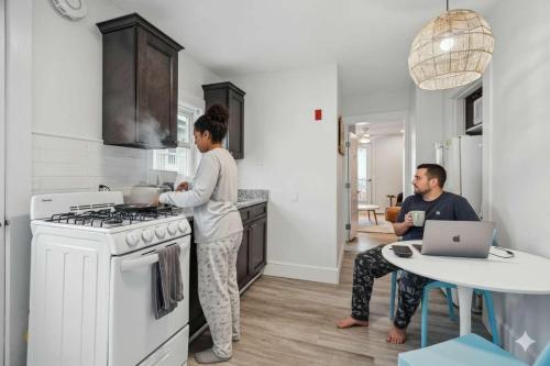 a man and a woman in a kitchen with a stove at Newly Renovated Private Balcony Steps to Beach in Hampton