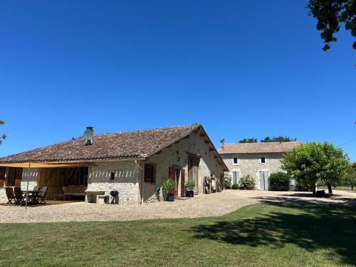 a large stone building with a grass yard in front of it at Le Grand Chene in Moustier