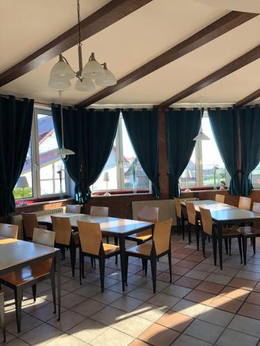 a dining room with tables and chairs and windows at Suederhof-Diemelsee in Diemelsee