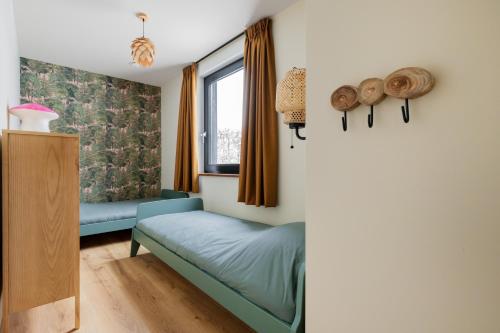 a bedroom with a bed and a window at Forest Villa De Bosburcht with Sauna | 6 persons in Gasselte