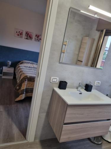 ein Badezimmer mit Waschbecken und ein Bett in einem Zimmer in der Unterkunft Affittacamere Ely in San Giórgio di Nogaro