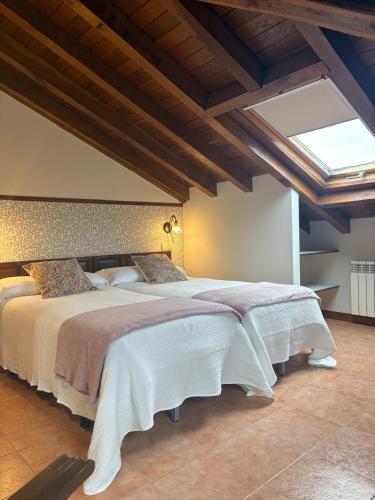 a bedroom with a large bed with a skylight at Eco de las Cuevas in Santillana del Mar