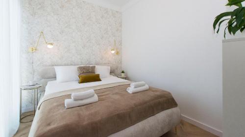a bedroom with a large bed with two pillows at Sol Marina - Marina 165 in Wiślinka