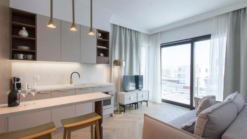a kitchen and living room with a couch and a tv at Sol Marina - Marina 165 in Wiślinka