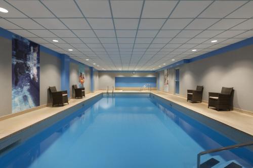 a large swimming pool with chairs and a pool at Coast Prince George Hotel by APA in Prince George