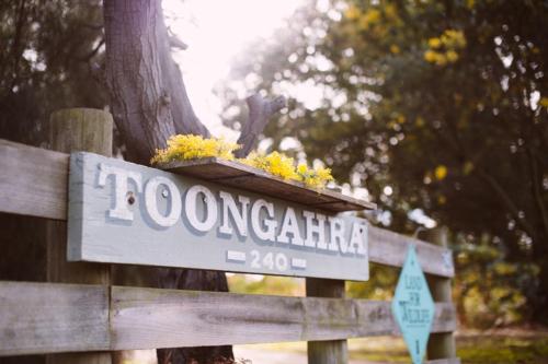 a sign on a wooden fence with flowers on it at TorquayToongahra BnB in Torquay