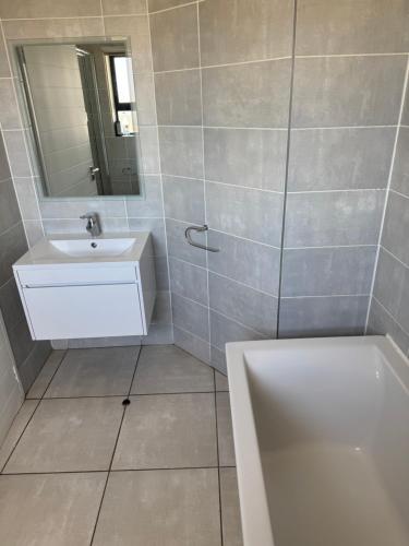 a bathroom with a sink and a mirror and a tub at The lagoon retreat in Avondzon