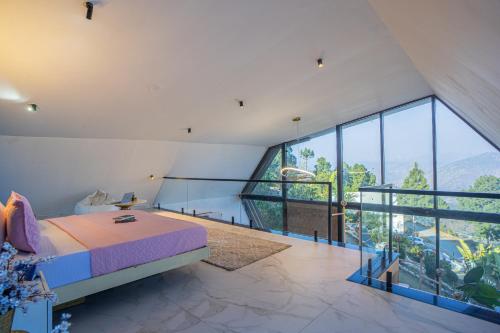 a bedroom with a bed and a large window at SaffronStays Luna Celeste in Rānīkhet
