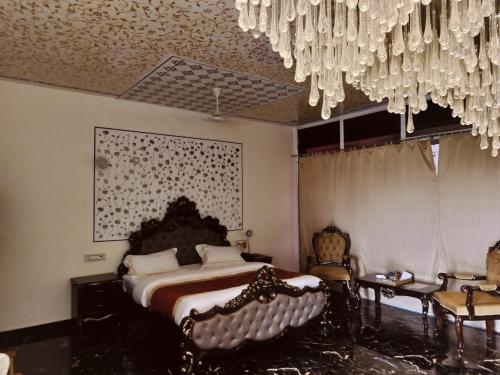 a bedroom with a bed and a chandelier at arham farm in Jāmb