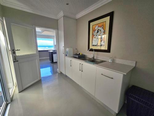 a kitchen with a sink and a counter top at Central, Beachfront Home in Jeffreys Bay