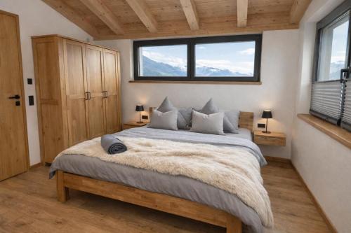 a bedroom with a large bed with a large window at Mountain Residence in Going am Wilden Kaiser