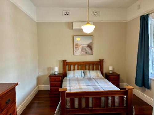 ein Schlafzimmer mit einem Holzbett und einem blauen Vorhang in der Unterkunft The Gregory in Geraldton