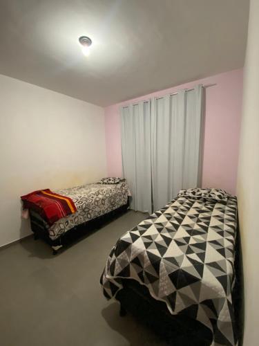 a bedroom with two beds in a room at Casa amarela in Santana do Riacho