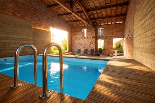 a swimming pool in a building with two metal handles at Le RELAIS in Lézat-sur-Lèze