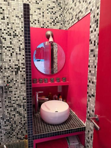 a red bathroom with a white toilet and a mirror at Vue Mer - appartement de charme - accès direct plage in Leucate-Plage