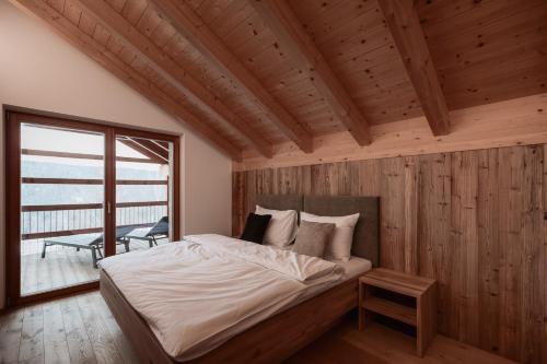 a bedroom with a bed in a room with a window at Deluxe Apartments Lantl in Falzes