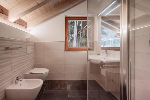 a bathroom with a toilet and a sink and a shower at Deluxe Apartments Lantl in Falzes