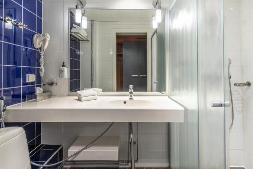 a bathroom with a sink and a glass shower at Scandic Postitalo in Tampere