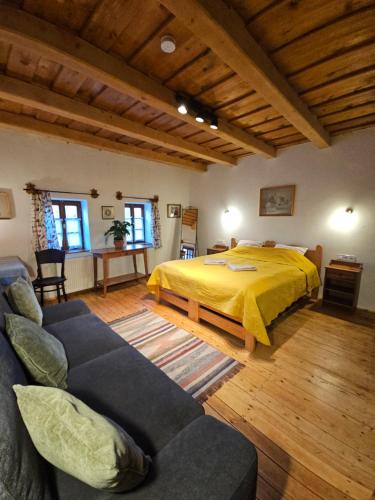 a bedroom with a bed and a couch at Füstös Cottage Gömörszőlős in Gömörszőlős