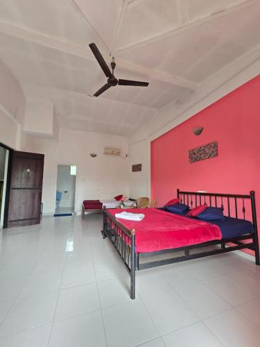 a bedroom with two beds and a red wall at Hotel Blue Mount View Kandy in Kandy