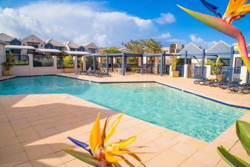 a swimming pool at a resort with lounge chairs at Margarets Beach Resort in Margaret River Town