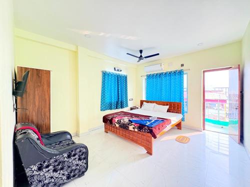 a bedroom with a bed and a couch and a window at Manas Kanya Mandarmani Hotel & Restaurant - Swimming Pool - Banquet - Parking Facility Full AC Room in Mandarmoni