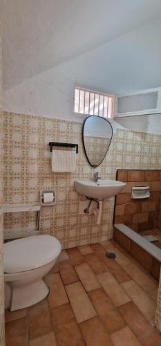 a bathroom with a sink and a toilet and a mirror at Niki's Cozy Home in Kalymnos