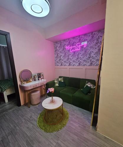 a living room with a green couch and a table at Kasara Serenity Condotel in Manila