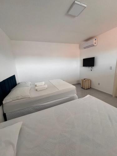 a bedroom with a bed and a tv on the wall at Pousada Flat Lourdes Residence in Angicos