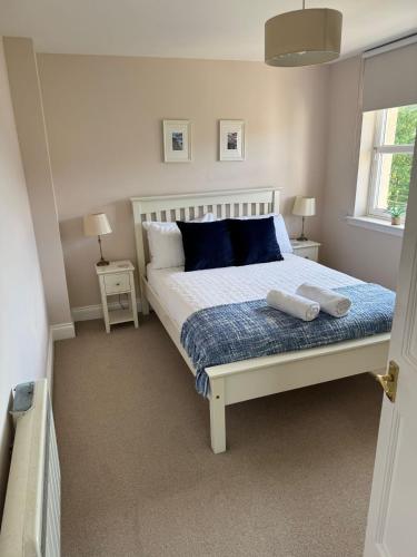 a bedroom with a bed with two towels on it at Two bedroom house in central Portree in Portree
