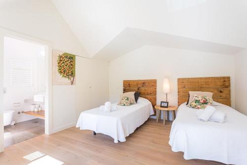 a bedroom with two beds and a bathroom with a sink at Villa Santamaria in Colares