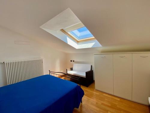 a bedroom with a blue bed and a skylight at Refugio Azul Baveno, pool and private parking in Baveno