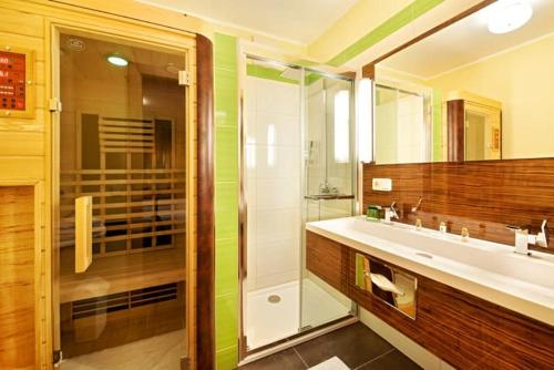 a bathroom with a glass shower and a sink at Revita Hotel Kocher in Sankt Agatha