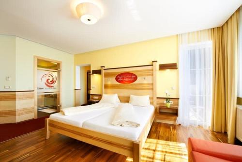 a bedroom with a large white bed in a room at Revita Hotel Kocher in Sankt Agatha