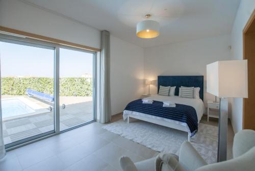 a bedroom with a bed and a sliding glass door at Villa del Rey III in Casal da Lagoa Seca