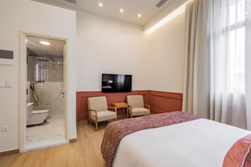 a hotel room with a bed and a bathroom at Promenade Chios Port Residences in Chios