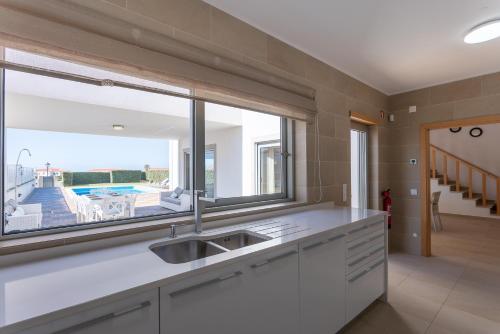 a kitchen with a sink and a large window at Villa del Rey VIII in Casal da Lagoa Seca