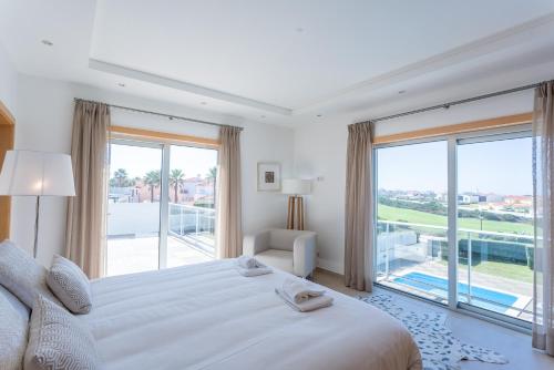 a bedroom with a large bed and a large window at Villa del Rey VIII in Casal da Lagoa Seca