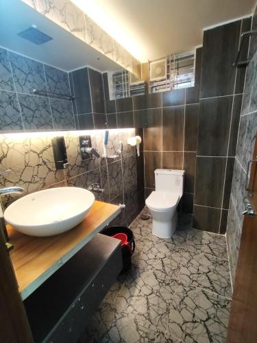 a bathroom with a sink and a toilet at MD HoTEL in Iswardi