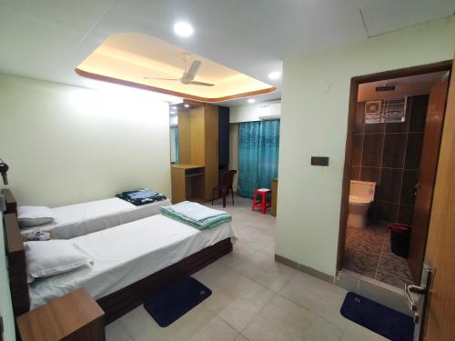 a hotel room with two beds and a bathroom at MD HoTEL in Iswardi