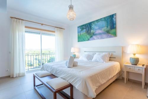 a bedroom with a large bed and a balcony at Villa del Rey VII in Casal da Lagoa Seca