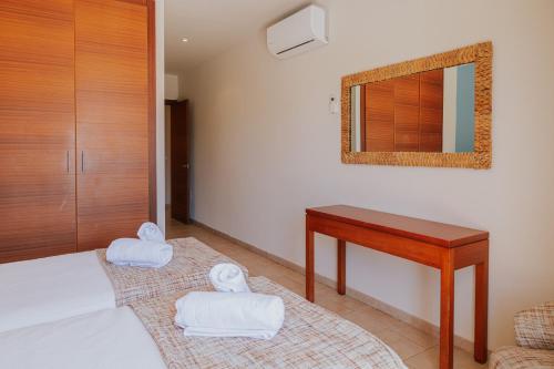 a bedroom with a bed with a desk and a mirror at Villa Santo Tomás - Loli in Santo Tomás