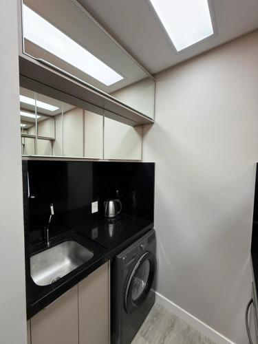 a kitchen with a sink and a washing machine at JD Village in Itapema