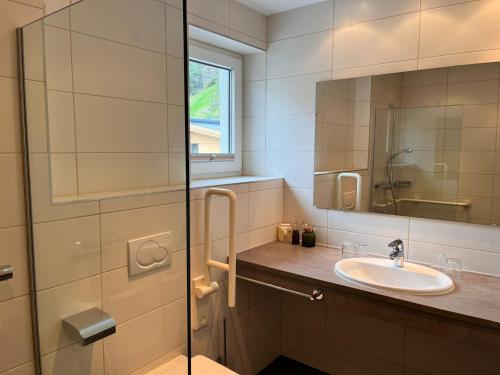a bathroom with a sink and a mirror at Sporthotel Bergheim in Sölden