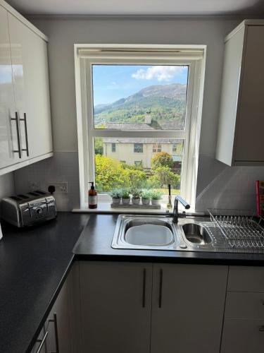 a kitchen counter with a sink and a window at Two bedroom house in central Portree in Portree