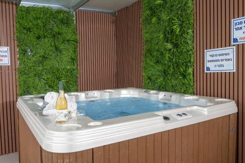 a jacuzzi tub in a room with plants at וילה ריש - וילה מהממת למשפחות עם חמאם תורכי במתחם, ממ"ד ובריכה פרטית in Yarka