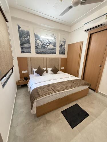a bedroom with a large bed with paintings on the walls at Hotel Krishna Tulsi Van - Near Bankey Bihari & ISKCON in Vrindāvan