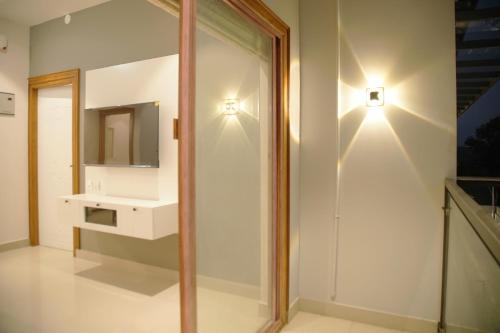 a bathroom with a white sink and a mirror at Gentur Enclave in Mananthavady
