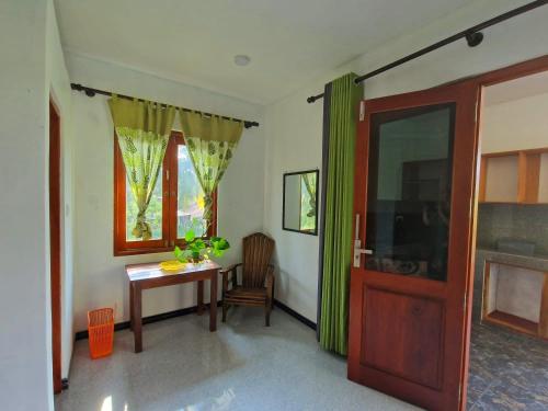 a room with a table and a window and a door at Mango Lodge in Aluthgama