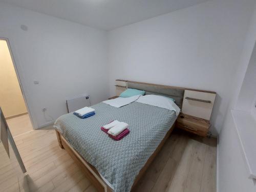 a bedroom with a bed with two towels on it at Onix 1 in Soko Banja